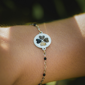 Bracelet Thalie confectionné à Mayotte en acier inoxydable et sable de Mayotte pour former un trèfle à quatre feuilles.